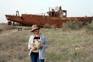 Lena stands in front of an abandoned fishing ship, no longer needed after large parts of the Aral Sea were drained.